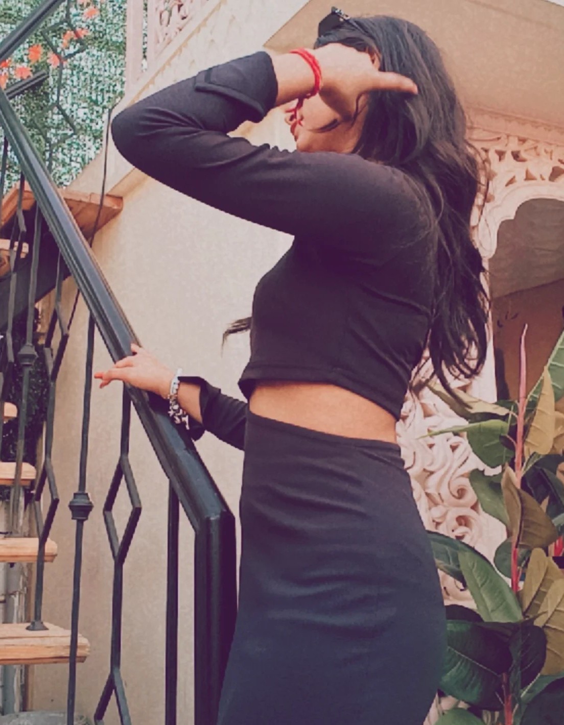 Tanya in a black outfit standing gracefully on a staircase