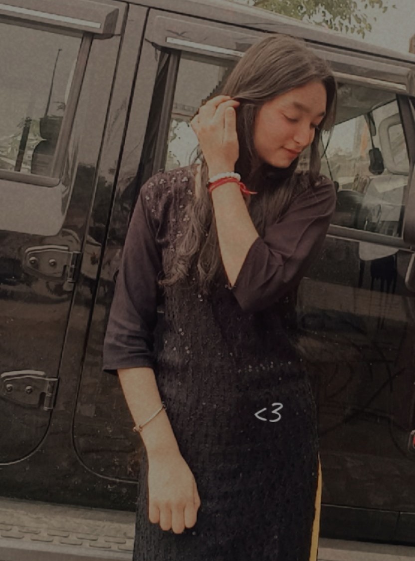 Tanya in a black sequined traditional outfit standing by a car